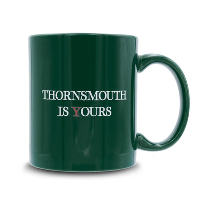 Green mug that reads thornsmouth is your's the Y is Red