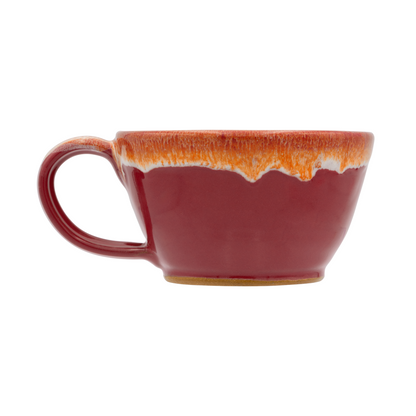 Red ceramic mug with orange rim on a white background